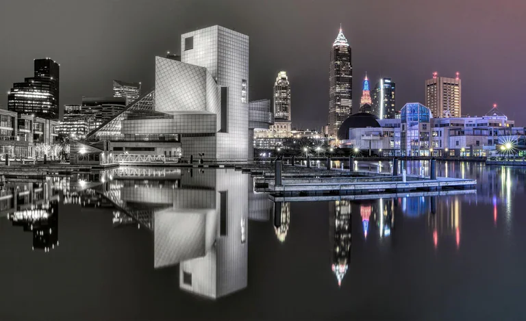 Cleveland waterfront with part of the skyline in black and white and colored reflections at the right.